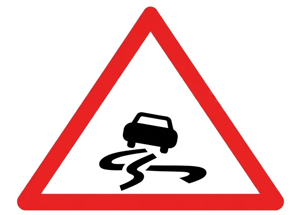 Red-bordered triangular sign showing a car with wavy skid marks behind it.